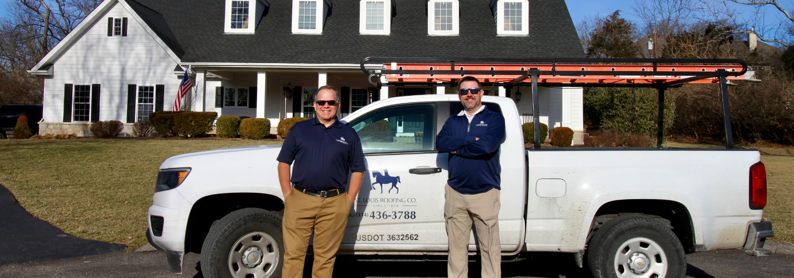 Chris and Rob, two roofing experts from Saint Louis Residential Roofing, pose in front of a home and truck.